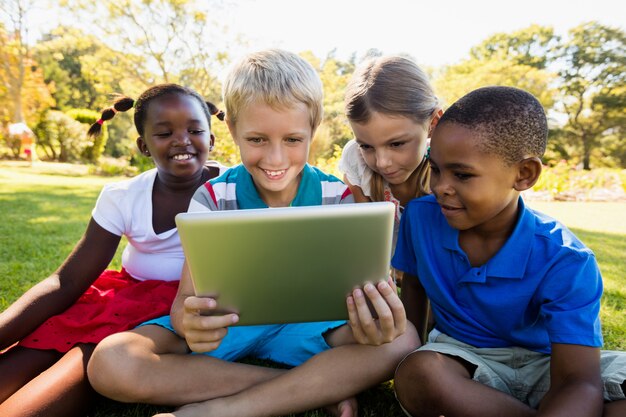 Niños usando tableta digital durante un día soleado