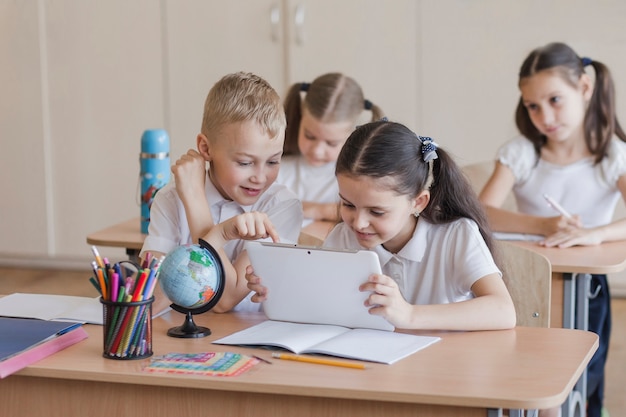 Niños usando tableta durante la lección