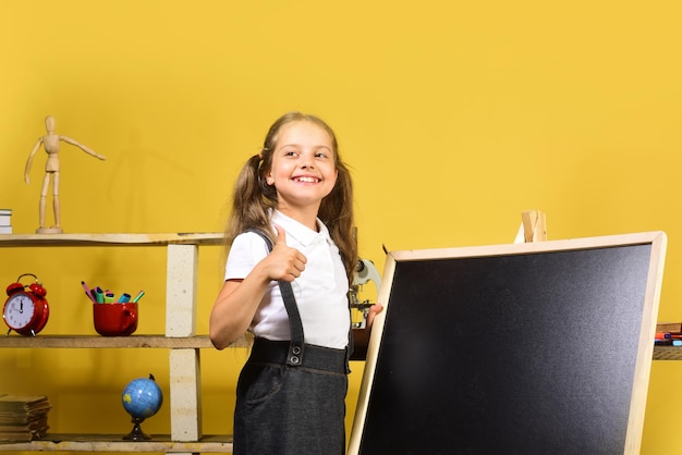 Niños y útiles escolares sobre fondo de pared amarilla