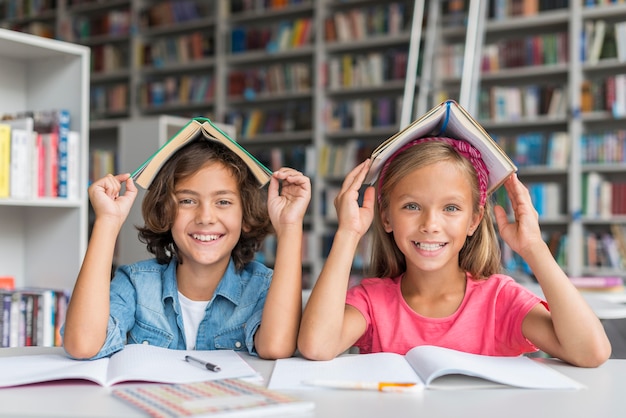 Foto niños de vista frontal posando de una manera tonta en la biblioteca