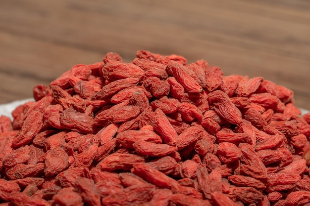 El níspero rojo está en un plato o cuenco sobre una mesa de madera.