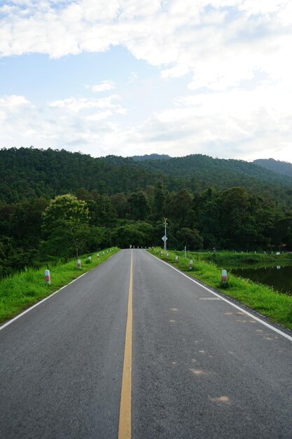 Foto nível da superfície da estrada por árvores contra o céu