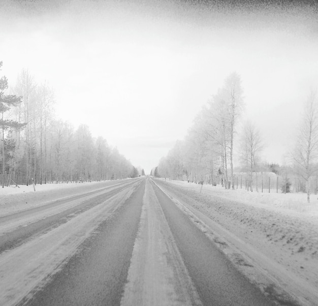 Foto nível da superfície da estrada vazia ao longo da paisagem coberta de neve