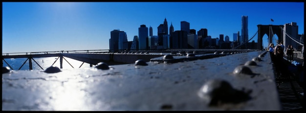 Foto nível de superfície da grade metálica na ponte de brooklyn contra o horizonte da cidade