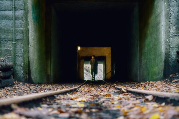 Foto nível de superfície de mulher caminhando em túnel