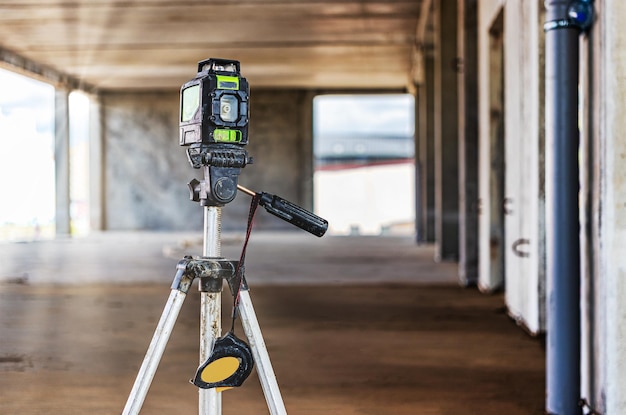 Nivel láser en un trípode en un sitio de construcción Primer plano Tomar medidas con un láser