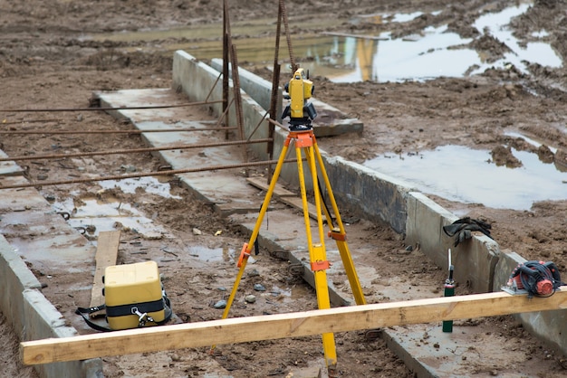 Nível óptico em um tripé em uma área de construção