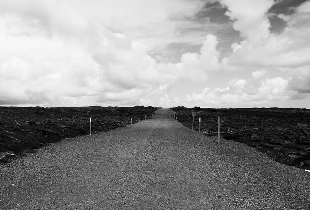 Foto nivel de la superficie de la carretera rural frente a un cielo nublado