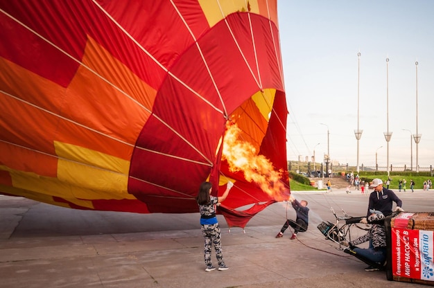 Nizhny Novgorod Rússia 20 de julho de 2019 festival de esportes aeronáuticos Uma equipe de balonistas infla seu balão com um queimador de gás e um ventilador para levar ao ar