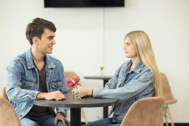 No aeroporto, um casal está esperando o embarque no lounge as pessoas estão esperando seus voos um jovem casal alegre posa com sua bagagem