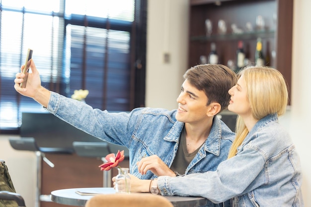 No aeroporto, um casal está esperando o embarque no lounge as pessoas estão esperando seus voos um jovem casal alegre posa com sua bagagem