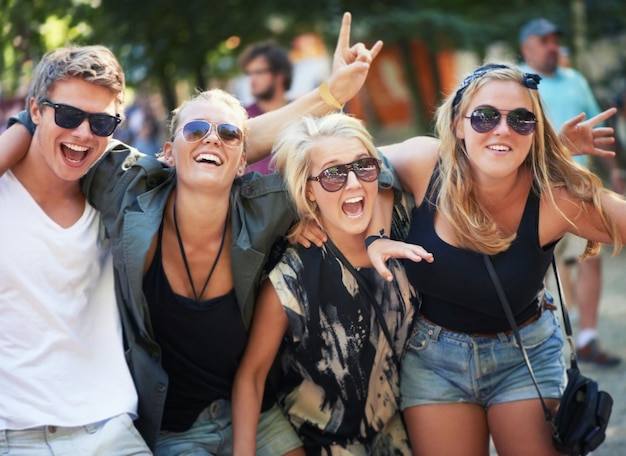 No alto da música e da vida quatro jovens amigos dançando com uma banda em um festival de música