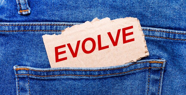 No bolso de trás da calça jeans há um pedaço de papel marrom com o texto evoluir