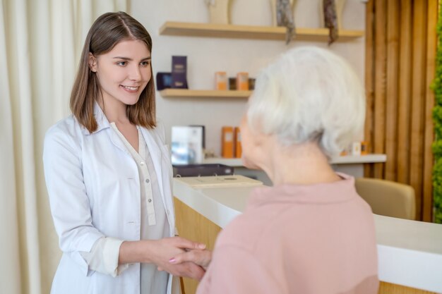 No centro de beleza. Mulher madura conhecendo um cosmetologista em um centro de beleza