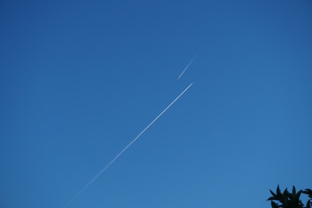 No céu, o traço de duas aeronaves voando em direção.