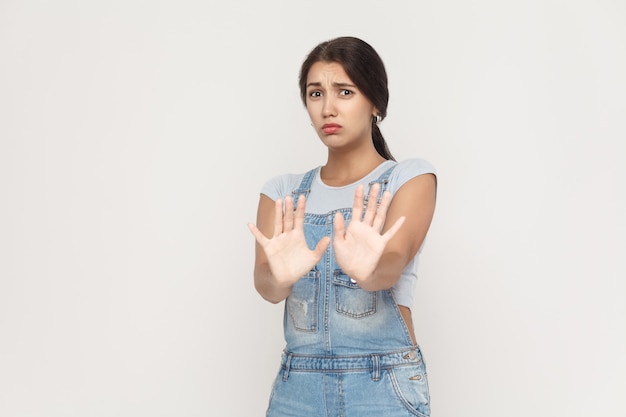 No es eso. Mujer adulta joven sorprendida posando sobre fondo gris. Aislado, tiro del estudio