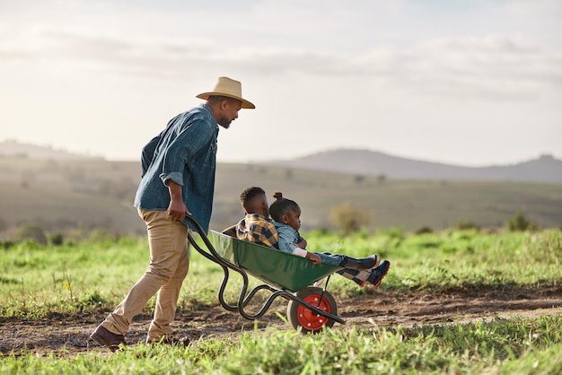 No es una granja sin una familia Foto de un hombre maduro que trabaja con su adorable hijo e hija en una granja