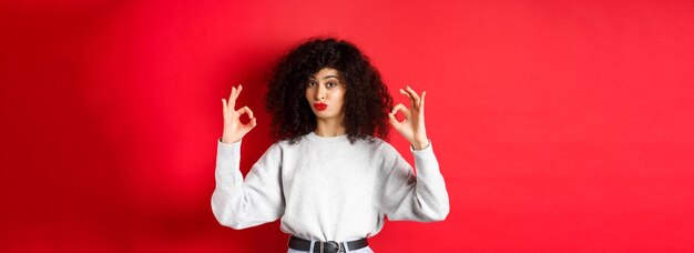 No está mal impresionado, la mujer rizada asiente con los labios fruncidos y muestra signos de aprobación como algo bueno.