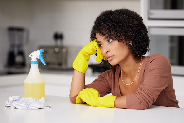 No estoy de humor para limpiar hoy. Foto de una mujer que parece infeliz mientras hace las tareas del hogar.