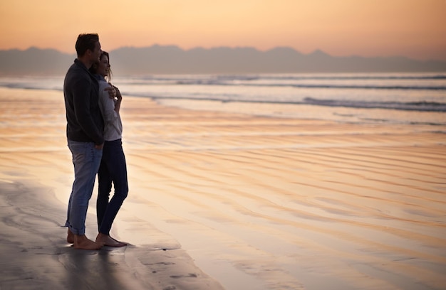 No hay nada como el amor joven Silueta de una pareja joven disfrutando de un paseo romántico por la playa