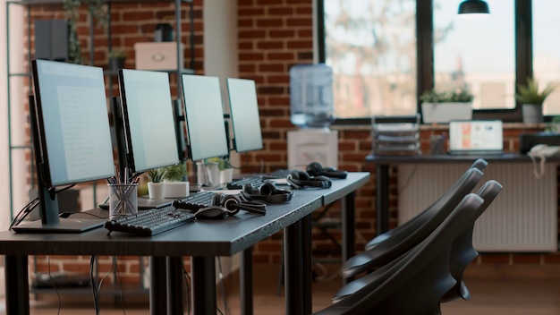 No hay personas en la oficina de servicio de atención al cliente con monitores para ayudar a los clientes con la asistencia de teletrabajo. Estación de trabajo vacía utilizada para telecomunicaciones de centros de llamadas, que brinda apoyo a las personas.