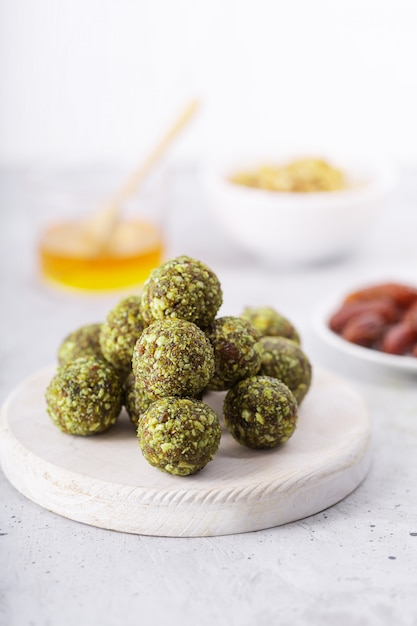 No hornee picaduras o bolas de energía matcha, preparadas con ingredientes naturales, como nueces, matcha en polvo, dátiles