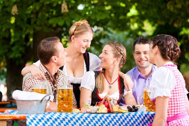 No jardim da cerveja - amigos em uma mesa com cerveja