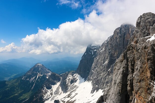 No pico de Dachstein e vista para as montanhas alpinas. Parque Nacional da Áustria, Europa. Céu azul e nublado em dia de verão