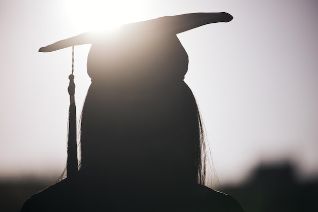 Foto no sabemos lo que depara el futuro. vista trasera de una mujer con un sombrero de graduación.