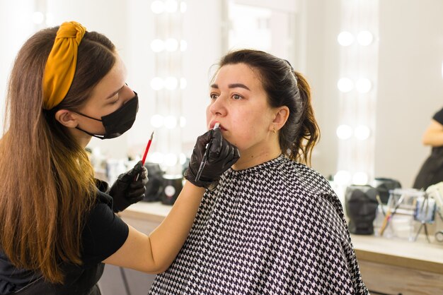 no salão de beleza, especialista em máscara e luvas faz maquiagem estilo de vida