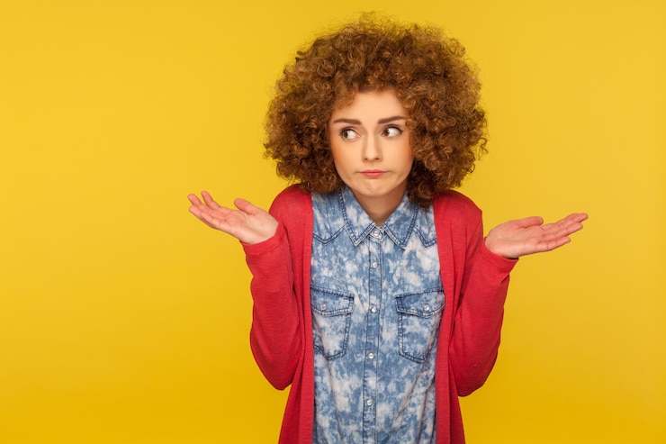 Foto no sé, tal vez. retrato de una mujer confundida, incierta y despistada con el pelo rizado y esponjoso levantando las manos con vacilaciones, dudando y pensando sin cuidado, indiferente a la pregunta. tiro de estudio interior