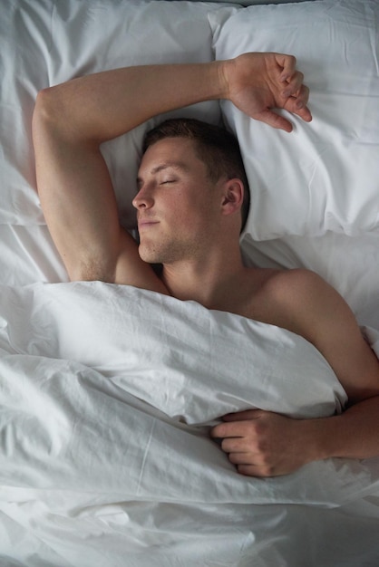 ¿No te gustaría despertarte junto a él? Captura recortada de un joven sin camisa durmiendo en su habitación.