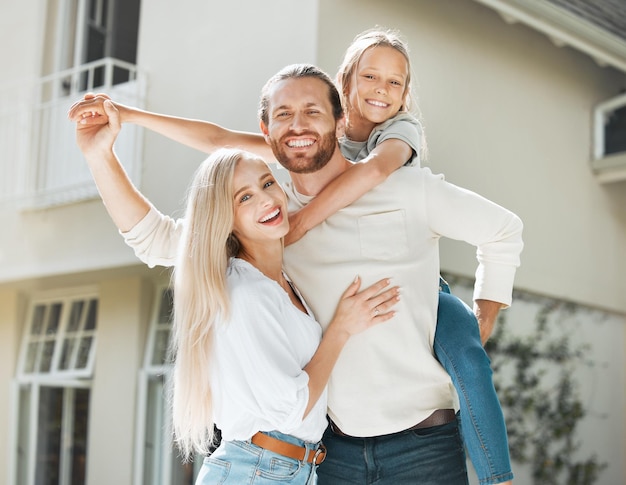 No se trata de la casa en la que vives, sino del amor que hay en ella. Toma de una pareja y sus dos hijos parados juntos afuera.