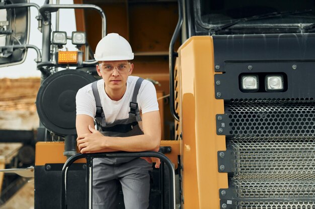 No veículo Trabalhador em uniforme profissional está no poço de empréstimo durante o dia