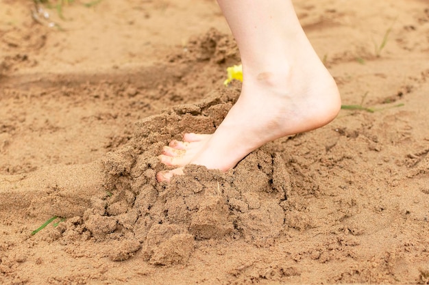 No verão a criança brinca na praia corre descalça na areia passeio no mar pés das crianças na areia entretenimento ao ar livrexa