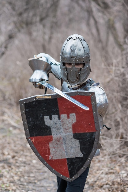 Noble guerrero Retrato de un guerrero medieval o caballero con armadura y casco con escudo y espada posando