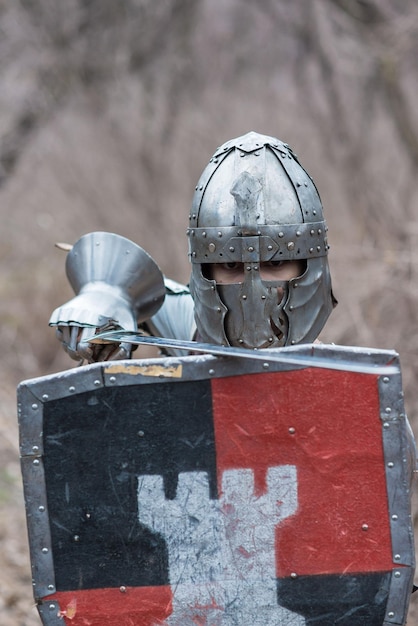 Nobre guerreiro Retrato de um guerreiro medieval ou cavaleiro em armadura e capacete com escudo e espada posando