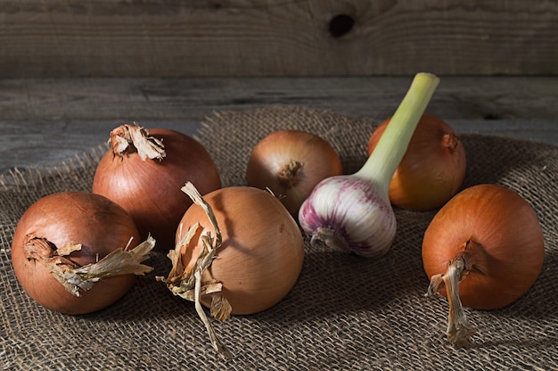 Noch Leben mit Zwiebel und Knoblauch auf altem Holztisch