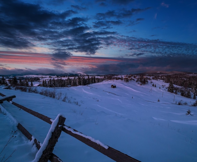 Noche campo colinas arboledas y tierras de cultivo en invierno remoto pueblo de montaña alpino Ucrania Voronenko