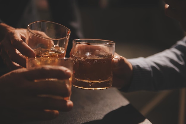 La noche de la celebración verter whisky en una copa dar a los amigos que vienen a celebrar