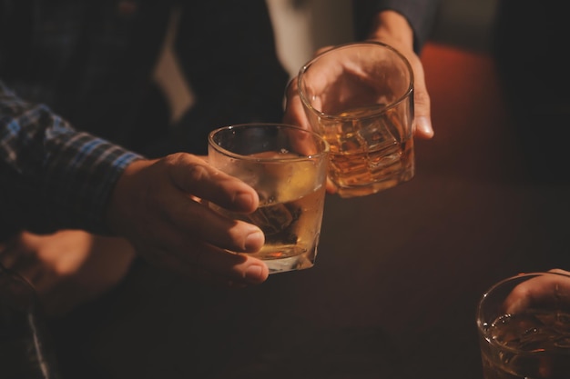 La noche de la celebración verter whisky en una copa dar a los amigos que vienen a celebrar