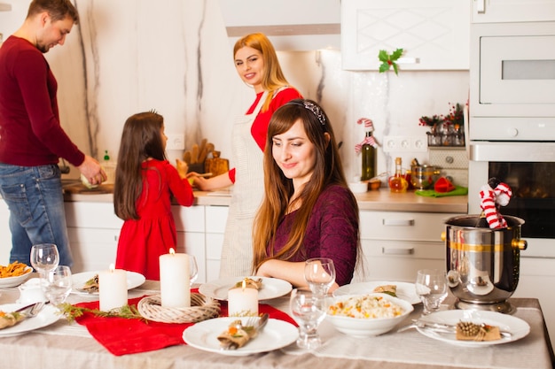 Noche de Navidad en casa, la familia prepara la comida y decora la mesa navideña