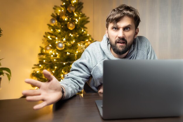 Por la noche, en la oficina, un hombre se sienta frente a una computadora en la víspera de Año Nuevo.