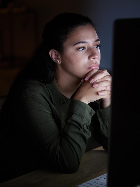 Noche seria y mujer en la computadora en la oficina trabajando hasta tarde en la propuesta y planificación de proyectos en línea Pensamiento de concentración y pantalla de lectura femenina para la red de Internet o la investigación del sitio web