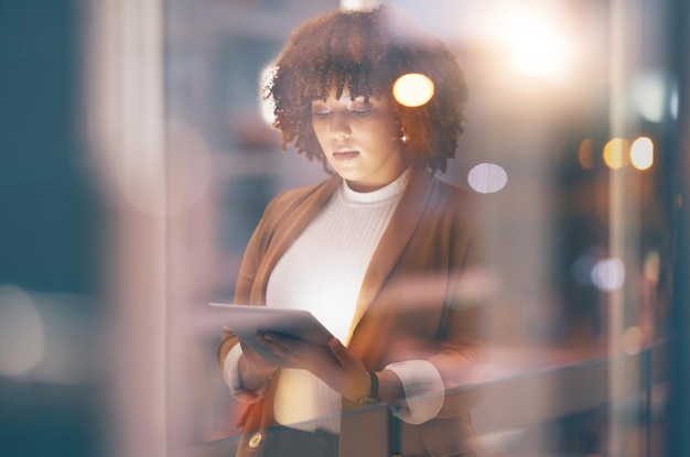 Noche de tabletas y mujer negra para investigación en línea, redes de Internet o planificación empresarial en ventana bokeh Trabajador profesional serio empleado o persona escribiendo o analizando tecnología digital