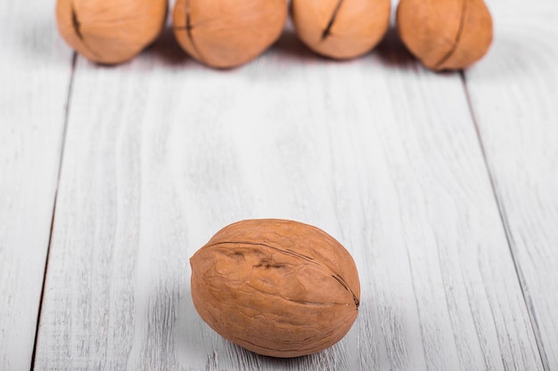 Nogal entero sobre fondo de madera el fondo de un montón de nueces en la mesa vintage de nogal claro borroso