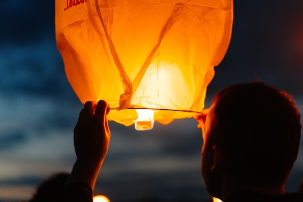 À noite, ao pôr do sol, as pessoas com seus parentes e amigos lançam lanternas tradicionais