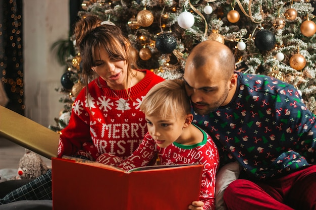 Noite de natal linda familia lendo um livro