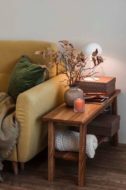 Noite de outono aconchegante uma poltrona com cobertor e travesseiro um banco de madeira com decoração em uma sala de estar aconchegante