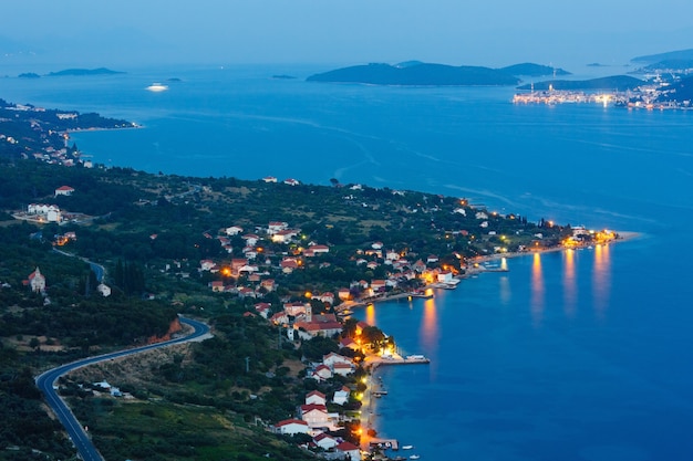 Noite de verão, litoral da península de PeljeÅ¡ac croata (Viganj, Croácia), e vila e ilha de Korcula ao longe.